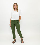 Woman dressed in Trailhead green pants paired with a white tee